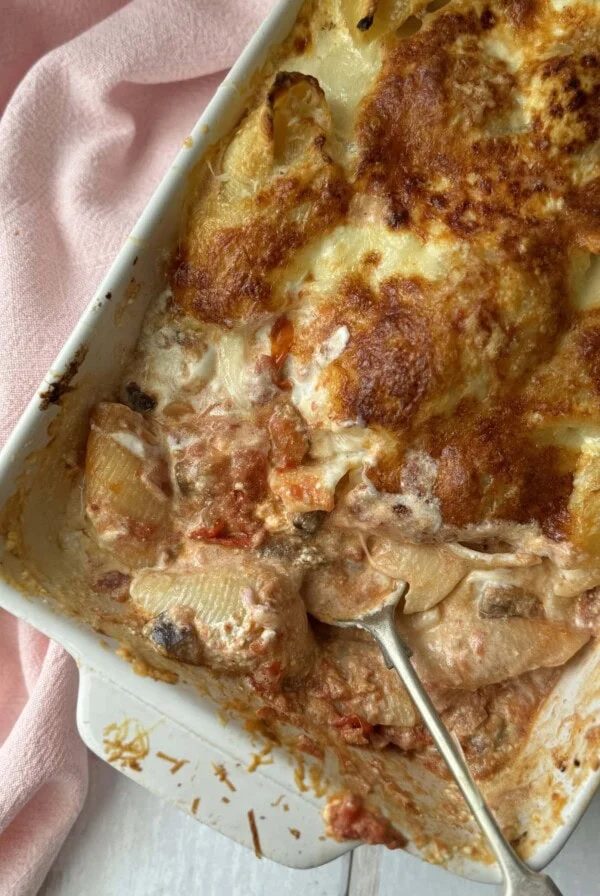 aubergine pasta with giant shells in a baking dish with a spoon