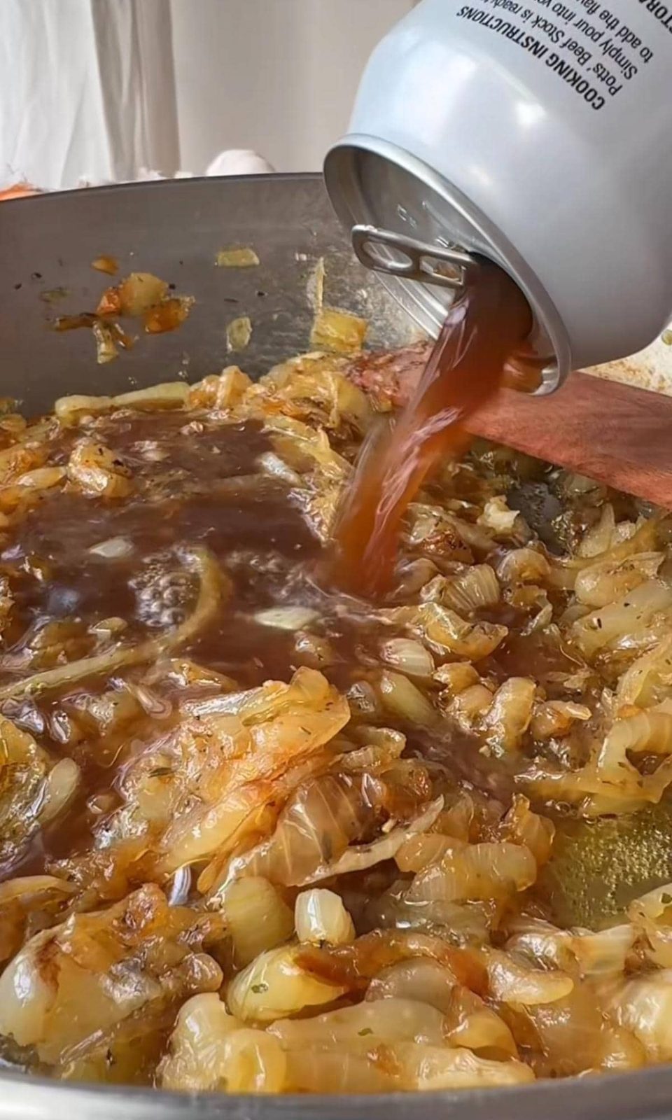Adding beef stock to onions.