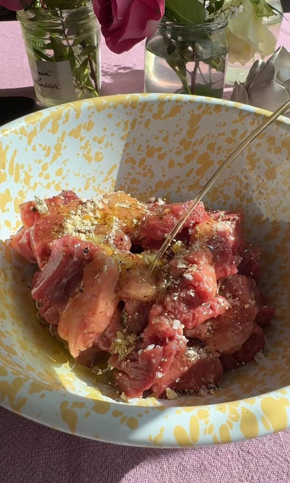 Seasoning chopped steak in bowl.