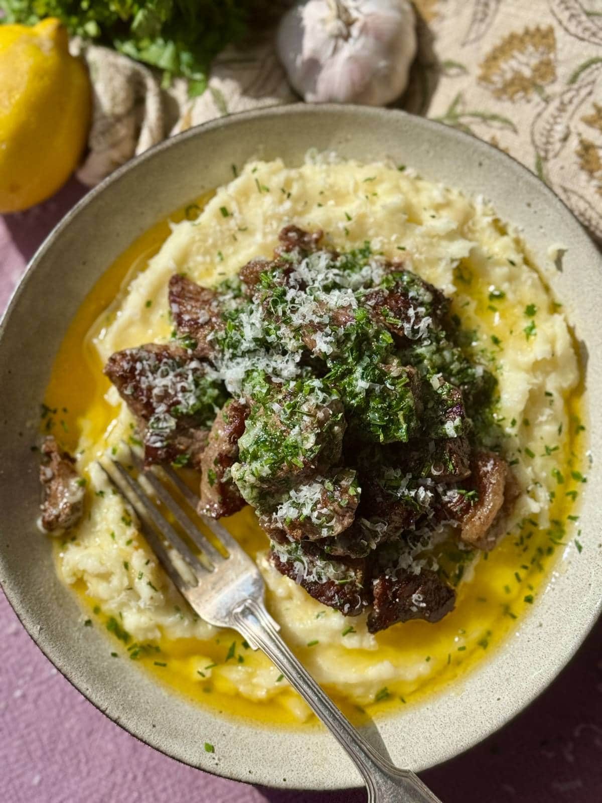 Garlic steak bites on a bed of mashed potatoes.