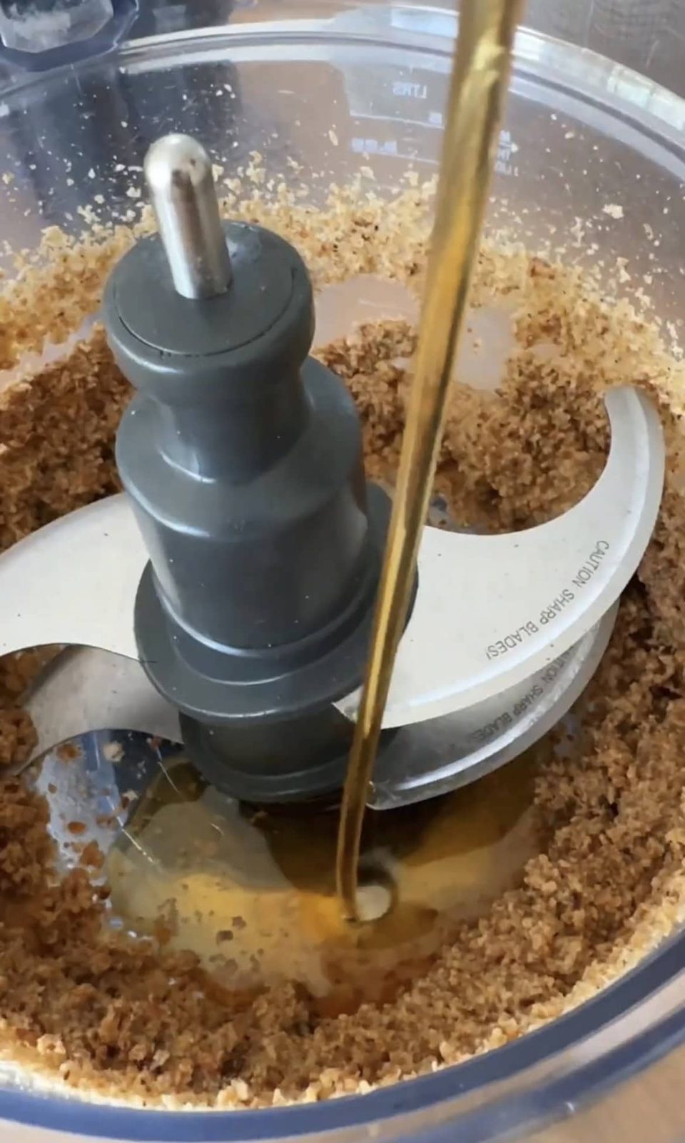 adding maple syrup to food processor.