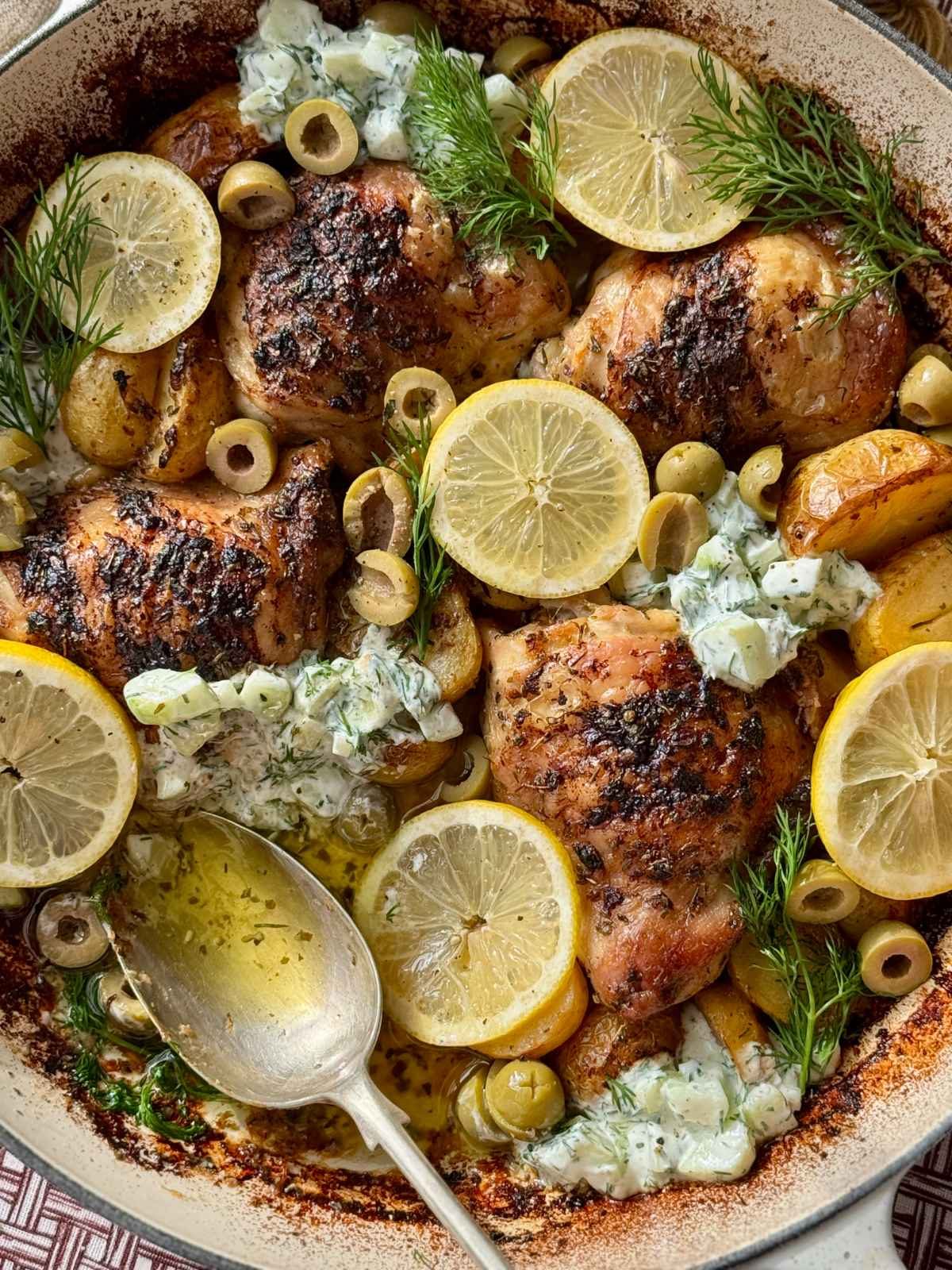 greek chicken lemon potatoes in a white dish.