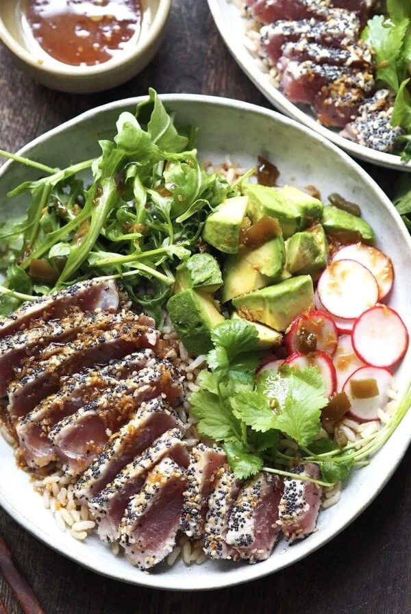 ahi tuna salad with garnishes on a white plate