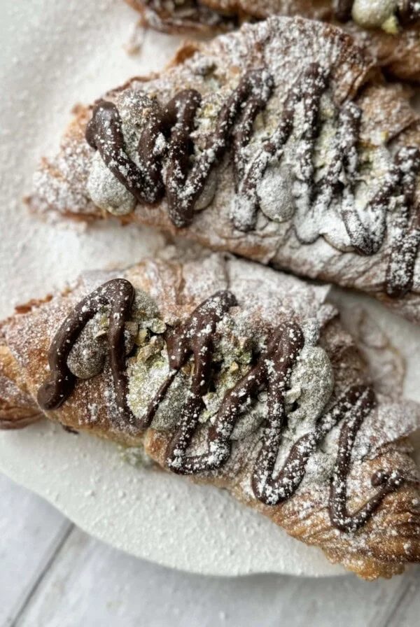 3 pistachio croissants dusted with icing sugar