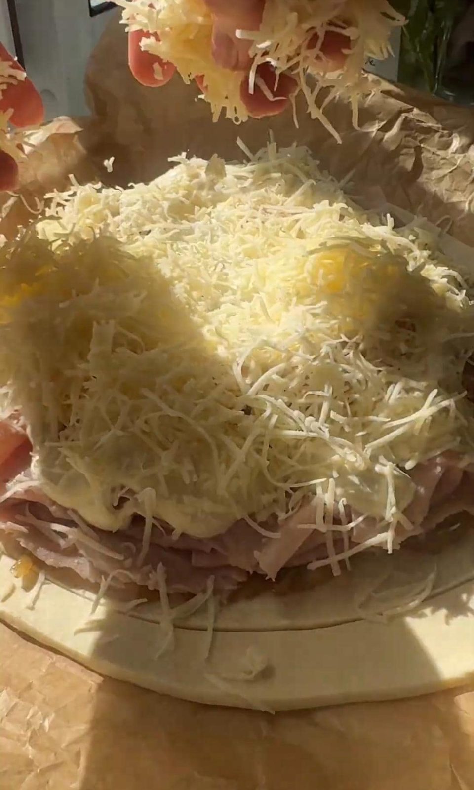 covering the pithivier with grated cheese.