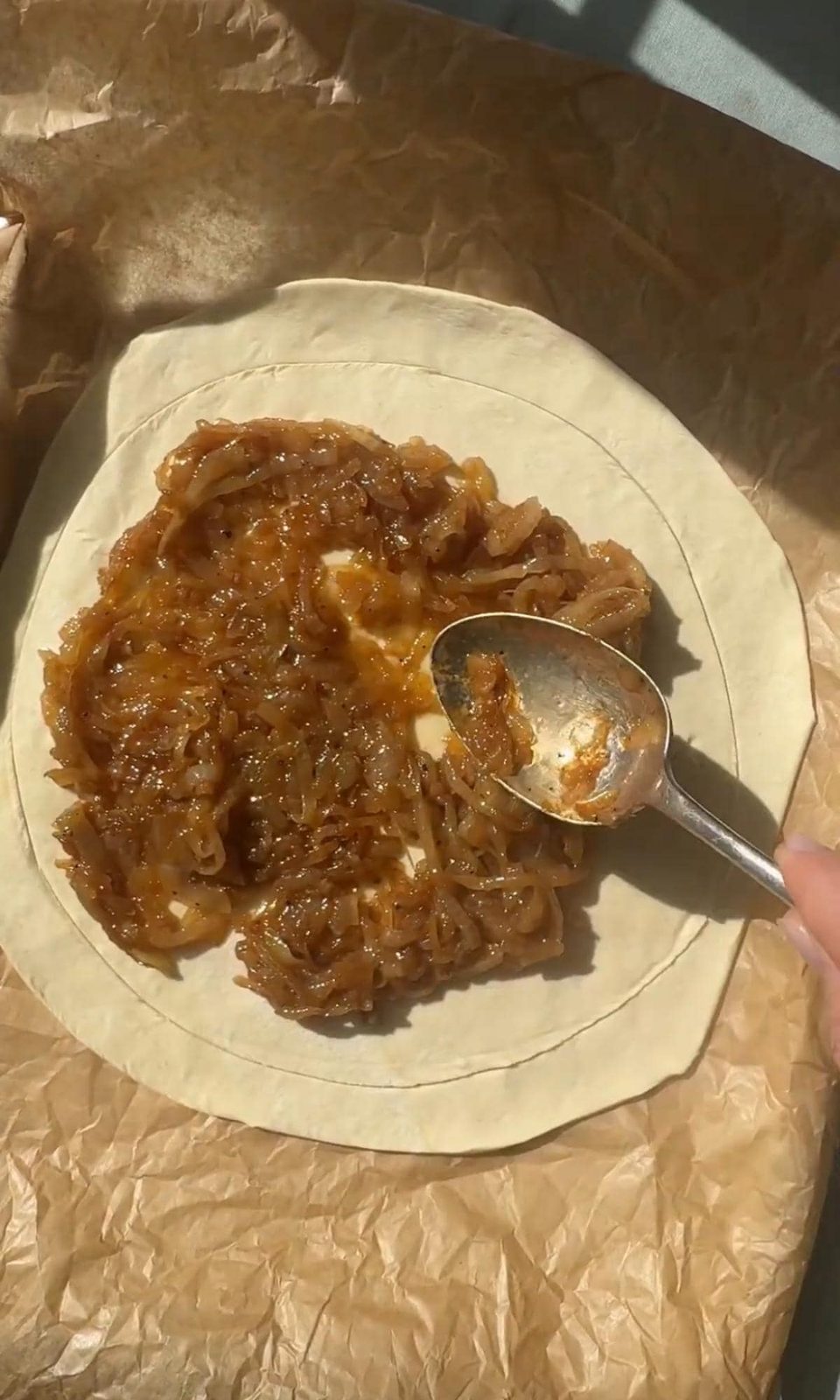 spreading caramelised onions on pastry base.
