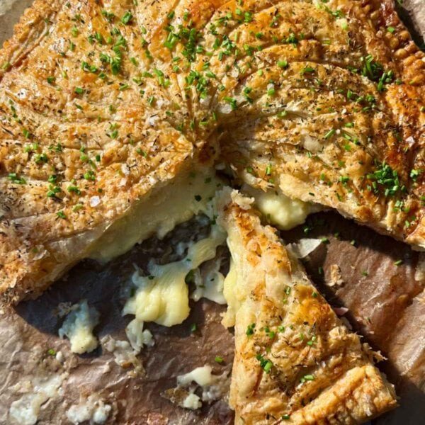a sliced pithivier on a wooden board.