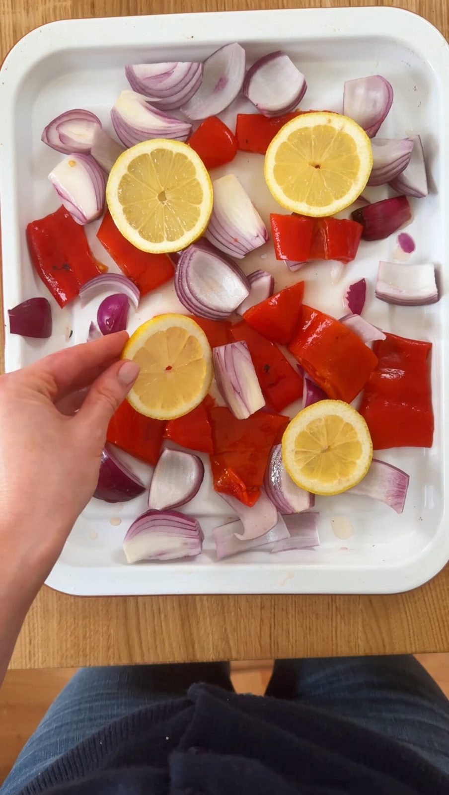 Layering peppers, onions, and lemons in roasting pan.