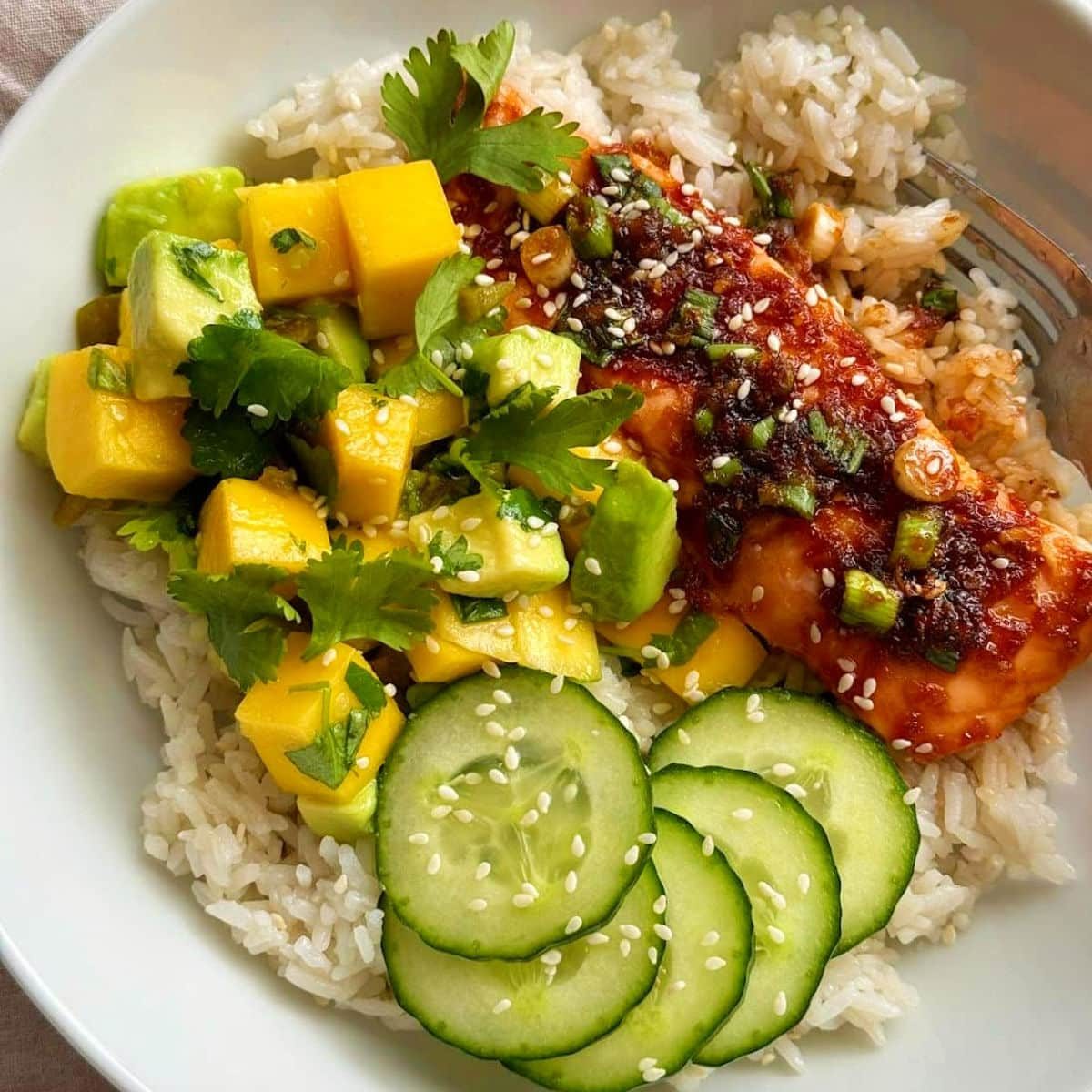 teriyaki salmon bowl with mango avocado salsa and rice.