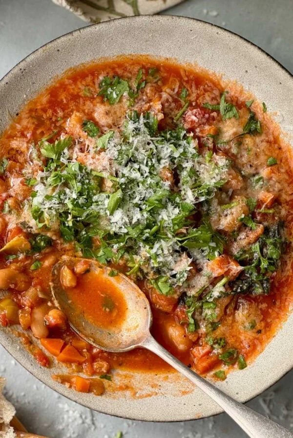 bean stew in a bowl with bread on the side.