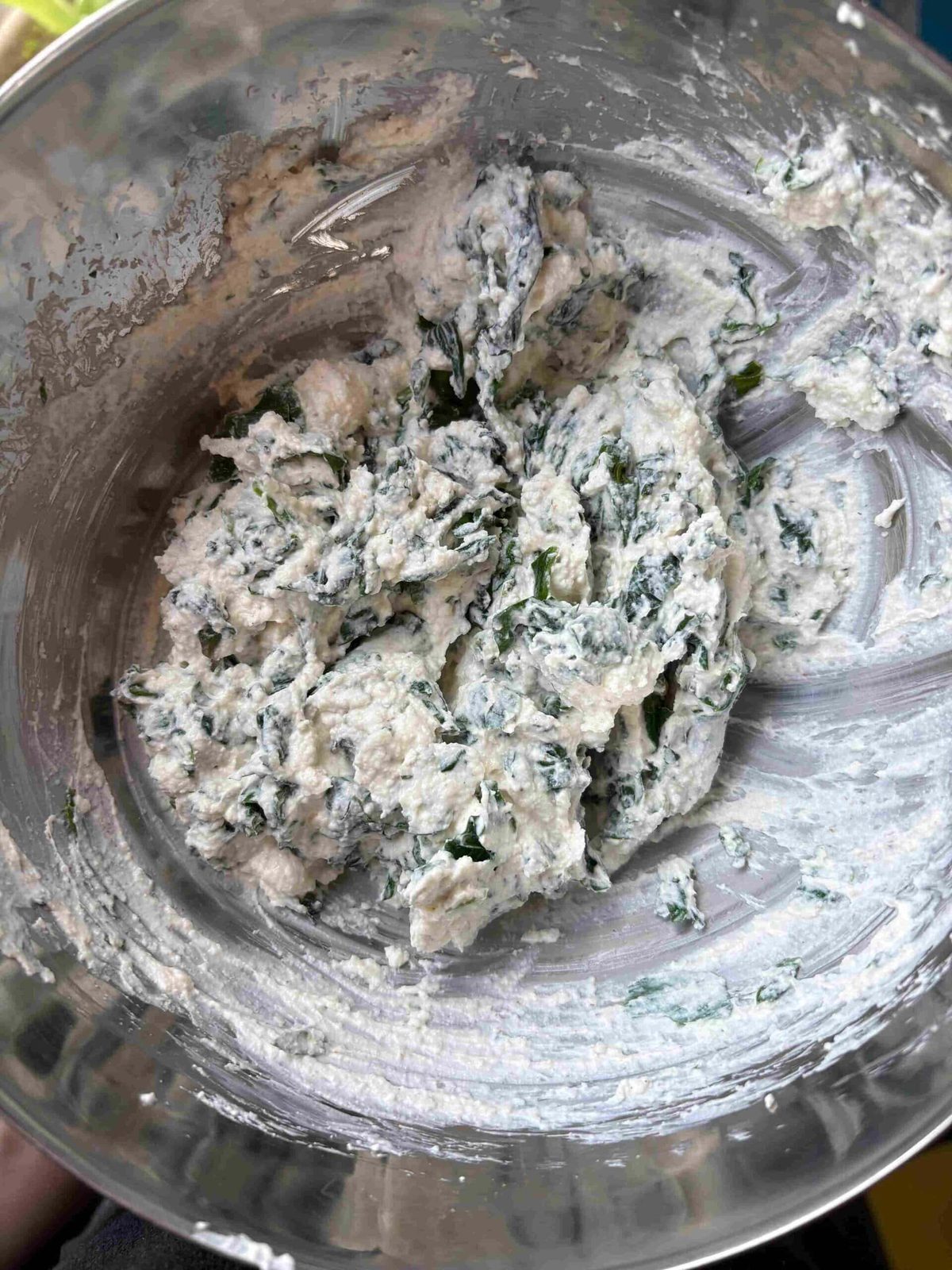 Spinach ricotta filling in glass bowl.