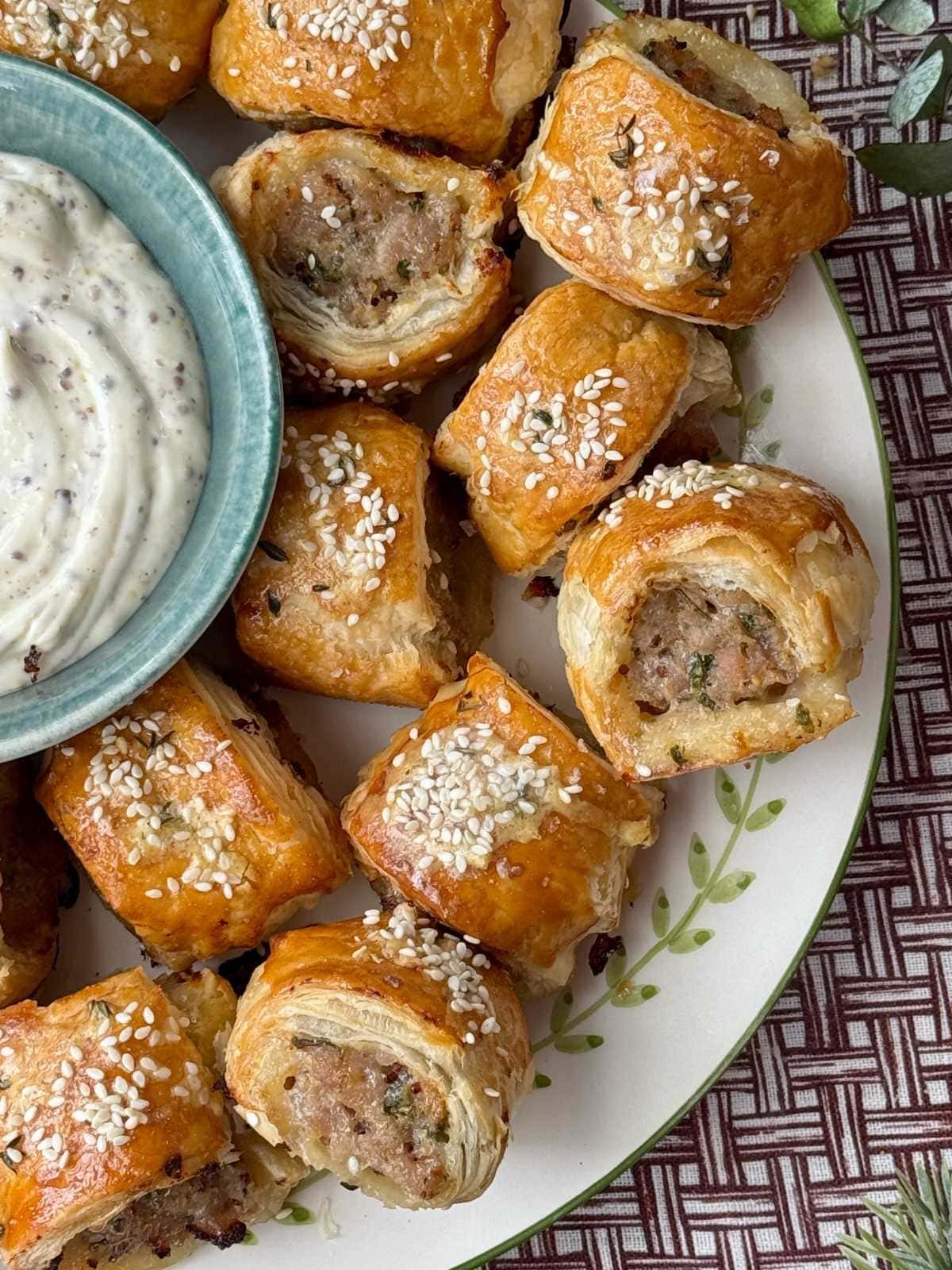 Easy sausage rolls on a plate with dipping sauce.