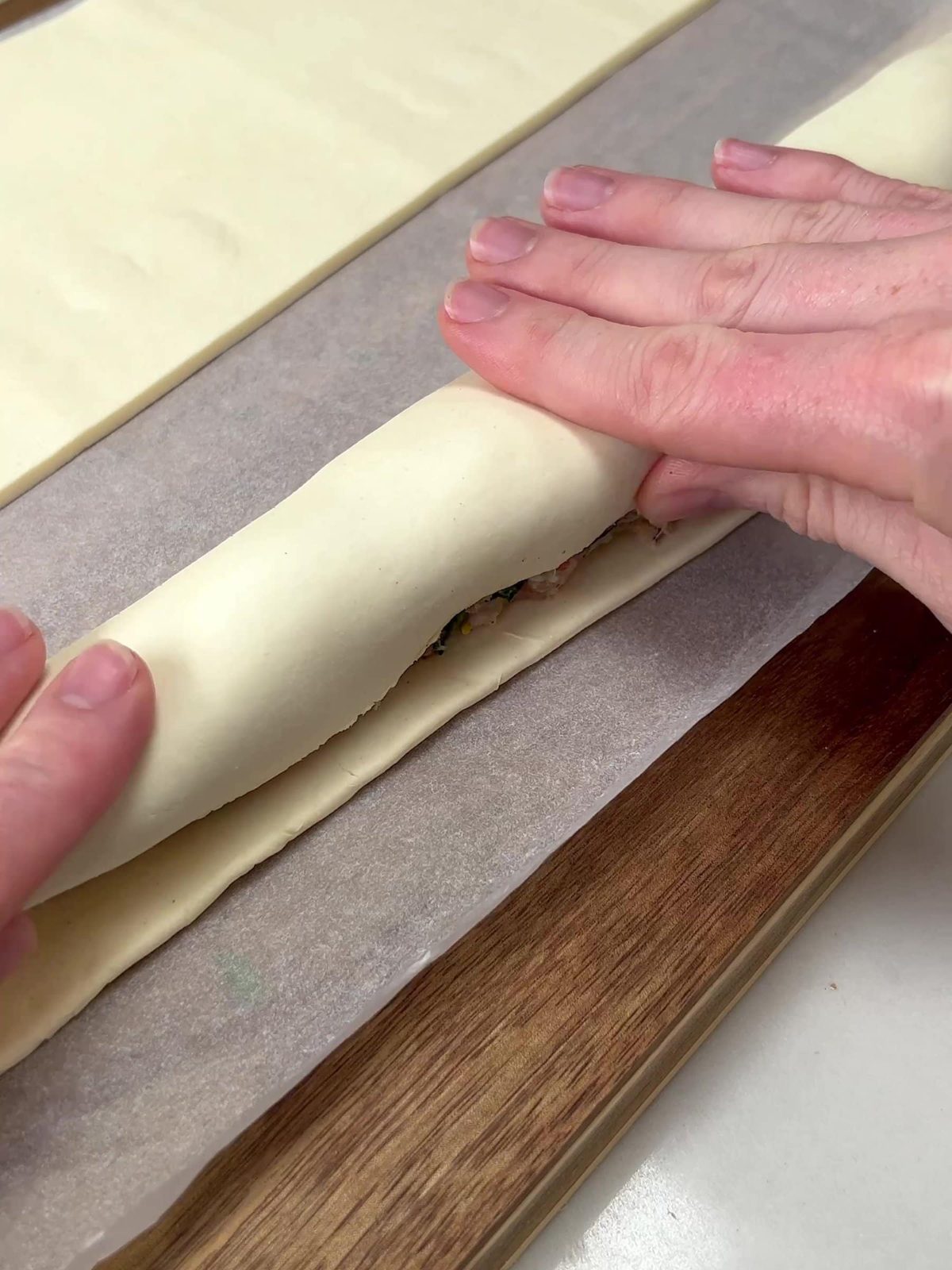 Wrapping pastry around sausage rolls.