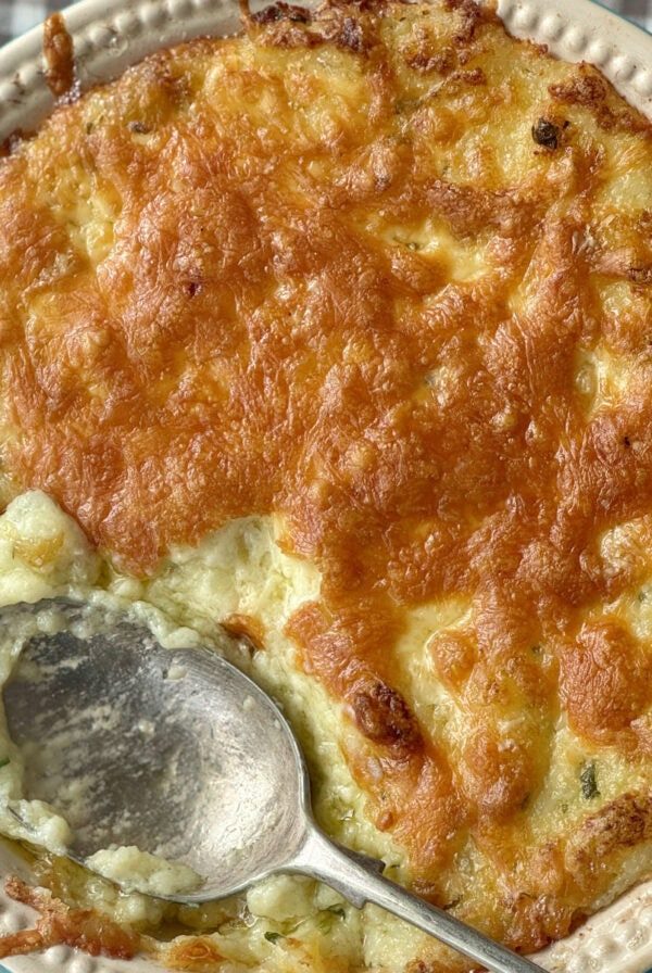 twice baked mashed potatoes in a dish with cheese on top.