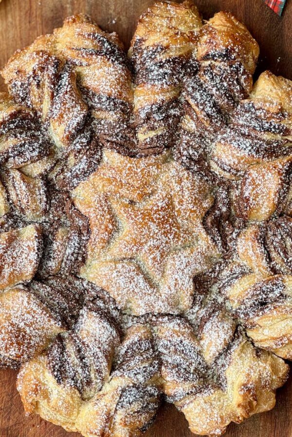 tarte soleil on a board with icing sugar.
