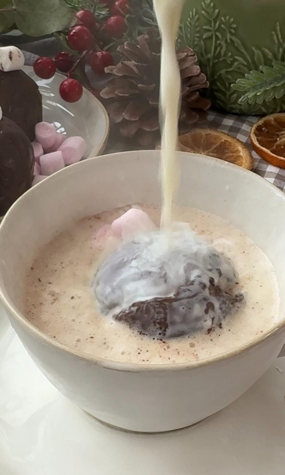 Pouring warm milk over hot chocolate bomb in bowl.
