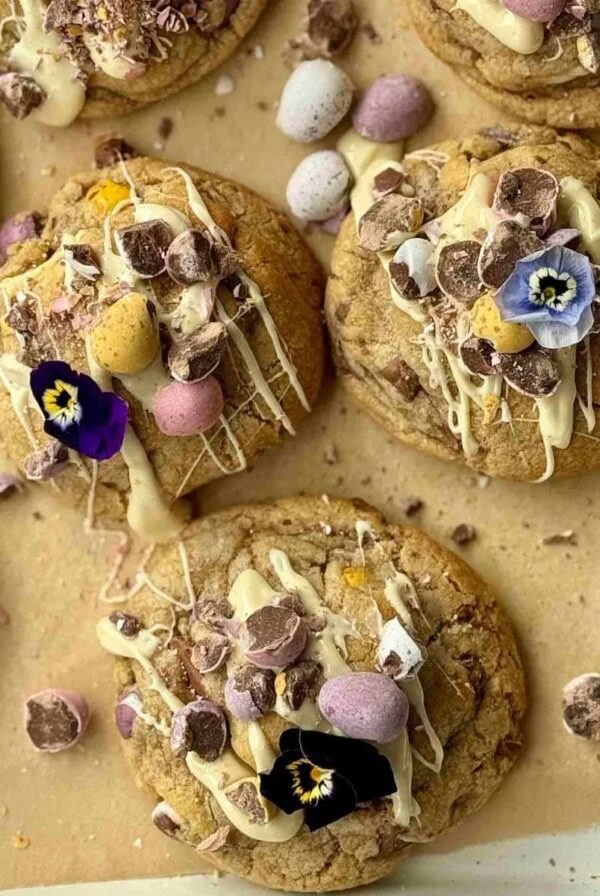 mini egg cookies drizzled with white chocolate with edible flowers.