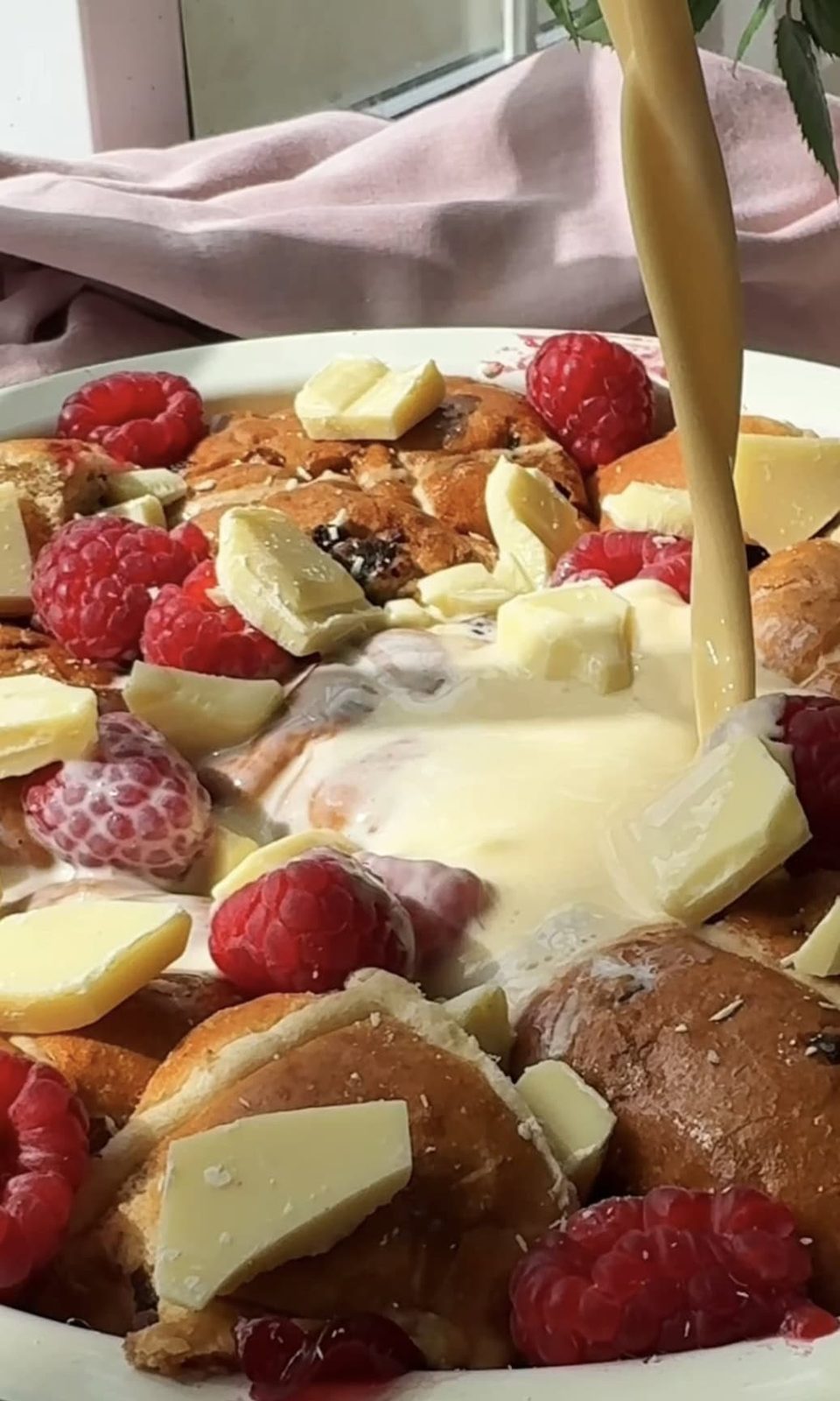 adding custard to hot cross bun bread and butter pudding.