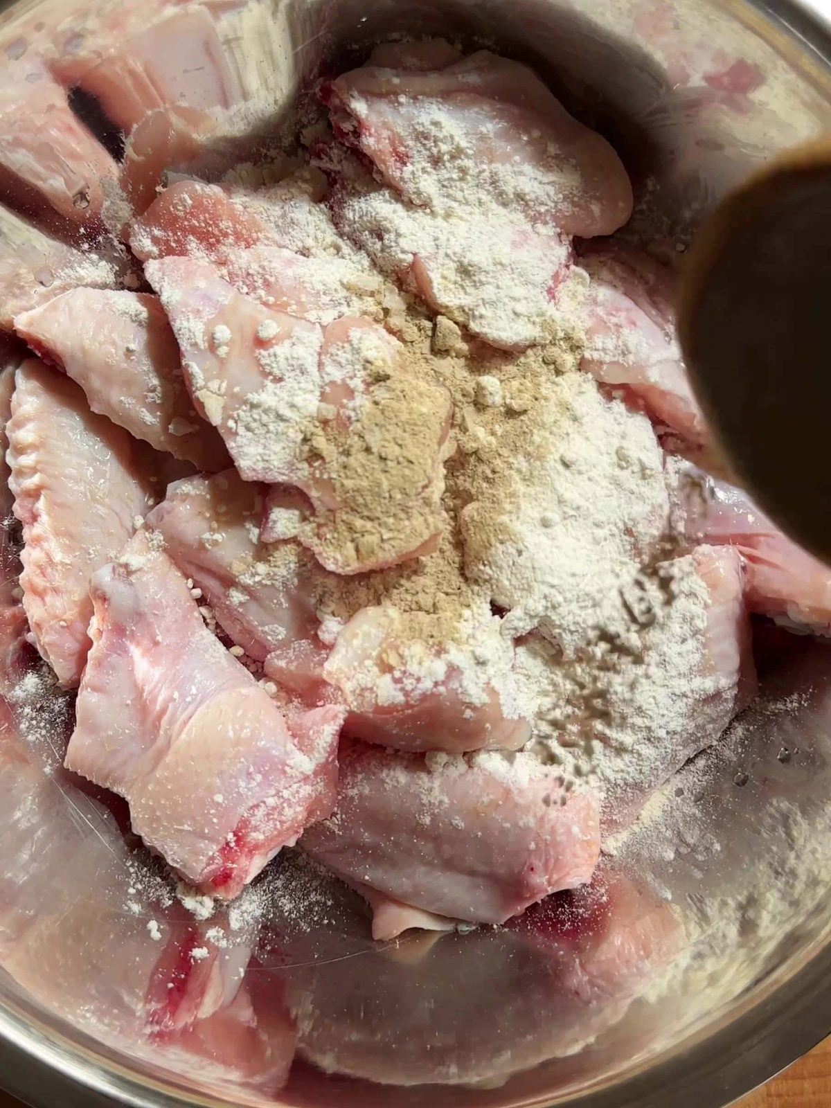 Coating chicken wing with seasonings.