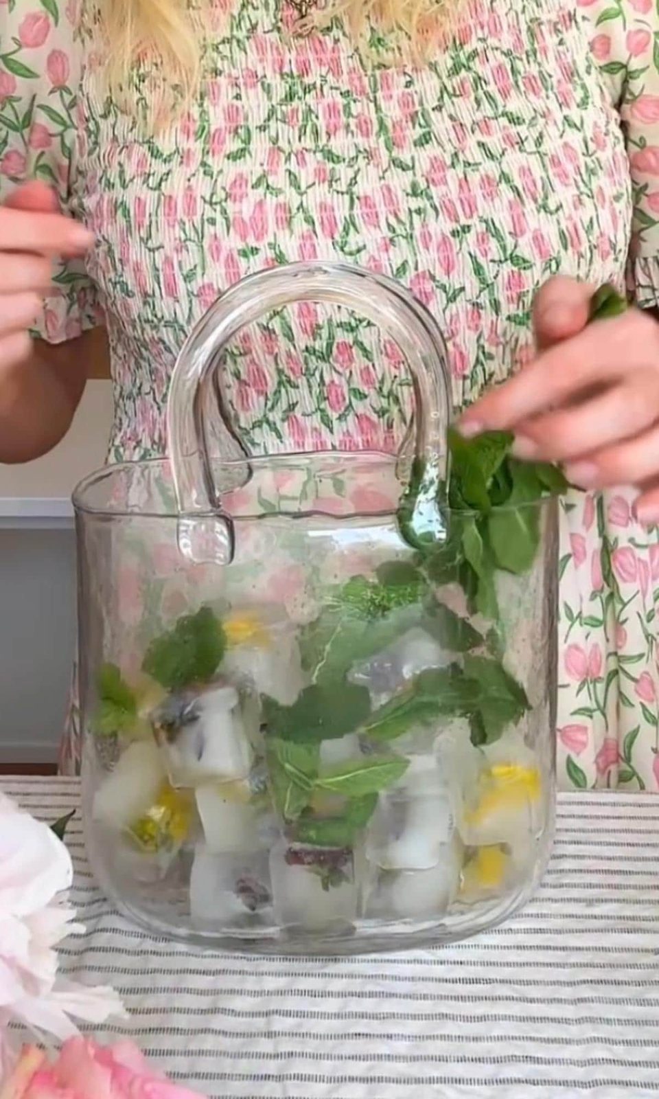 adding ice and mint to the glass.