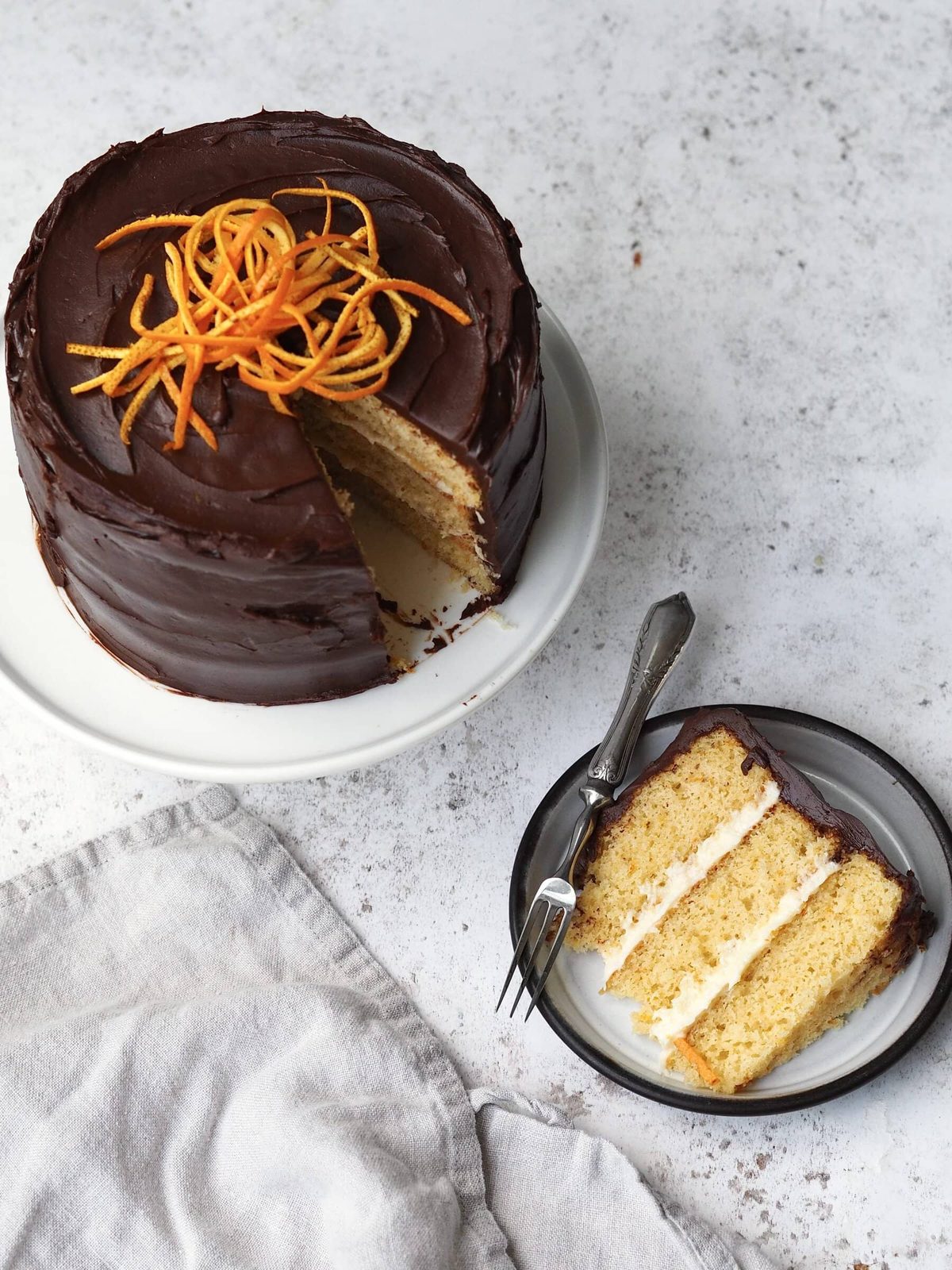 Jaffa cake cake with a slice removed on a black plate.