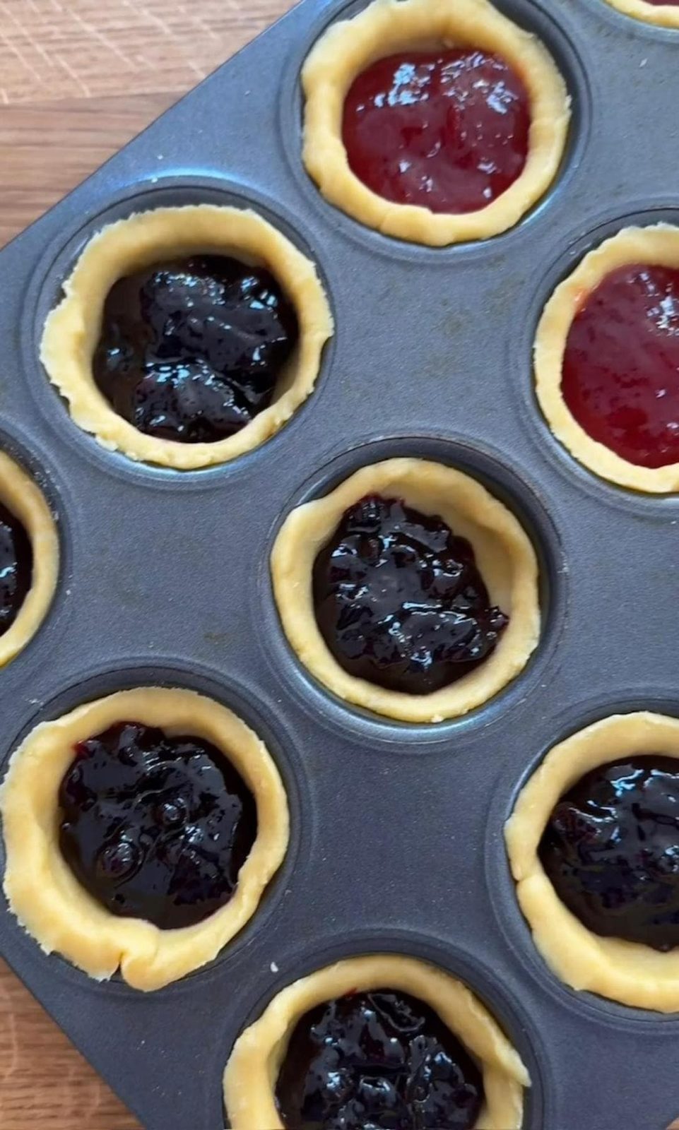 spooning jam into tartlets.