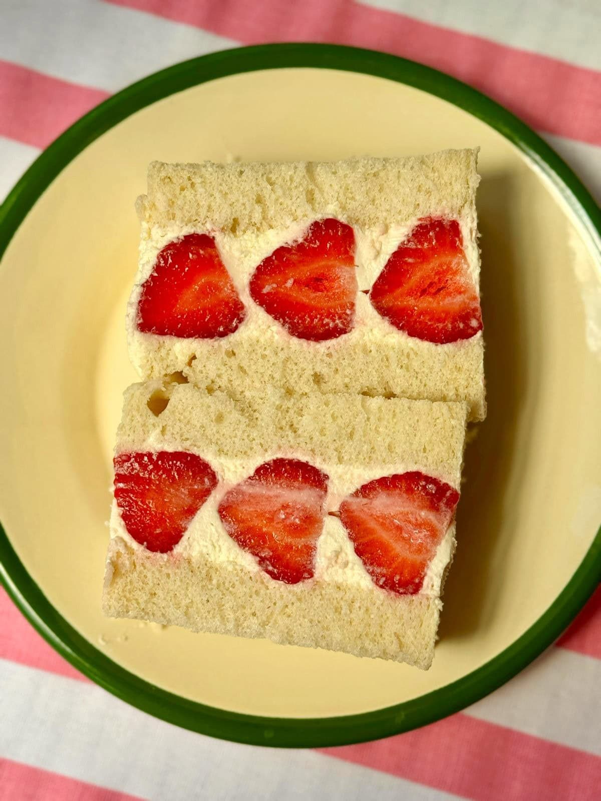 japan strawberry sandwich on a white plate with green rim.