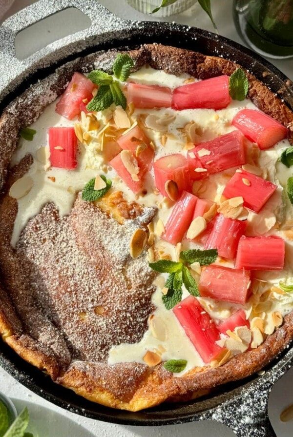 pannukakku in a cast iron pan with whipped mascarpone cream and poached rhubarb.