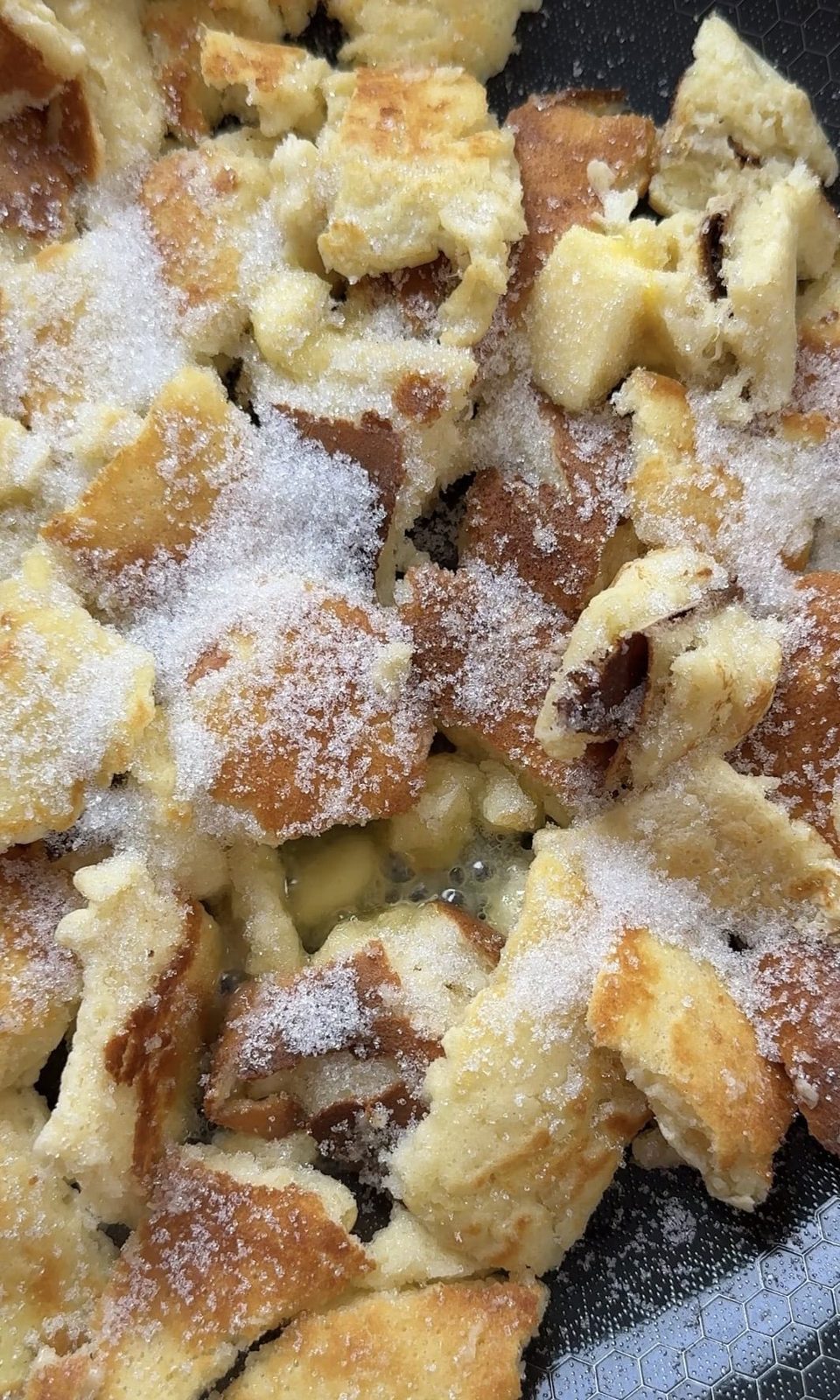 adding butter and sugar to Kaiserschmarrn.