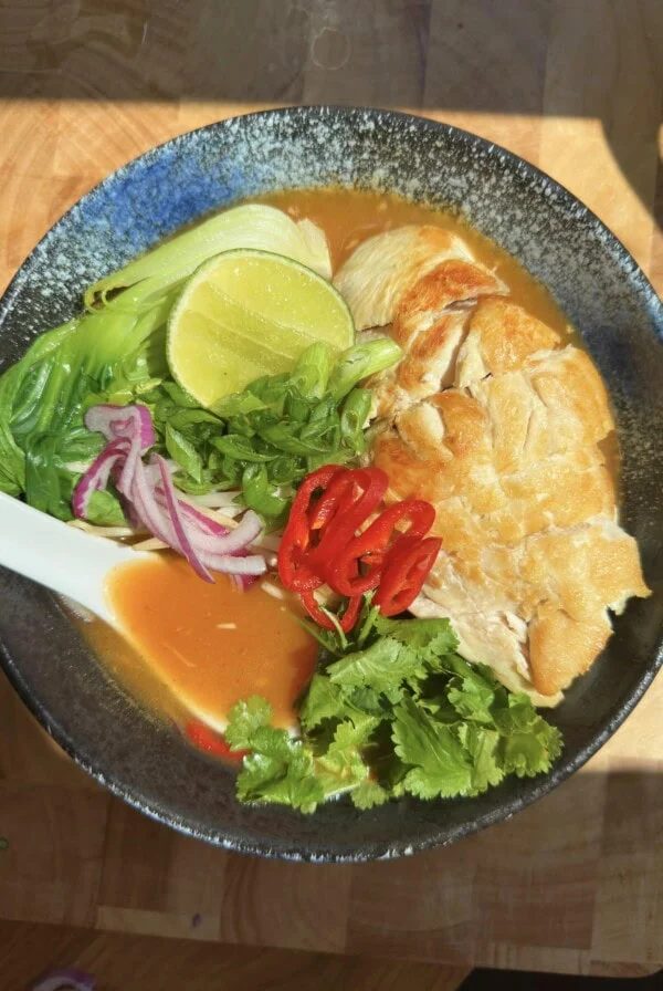 wagamama chilli chicken ramen in a blue bowl with a ramen spoon