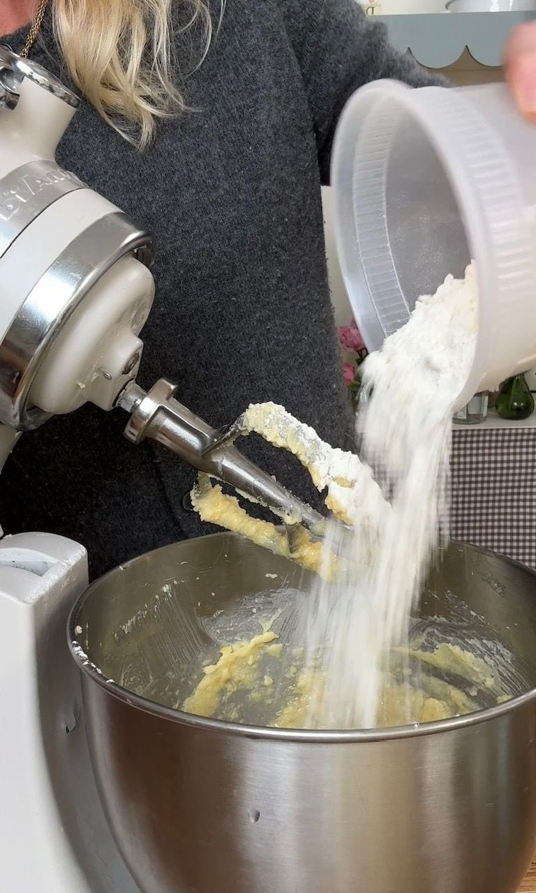adding flour to the cake batter.