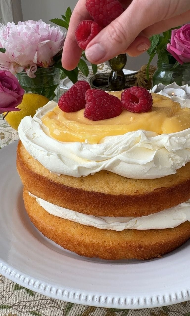 topping lemon curd cake with raspberries,