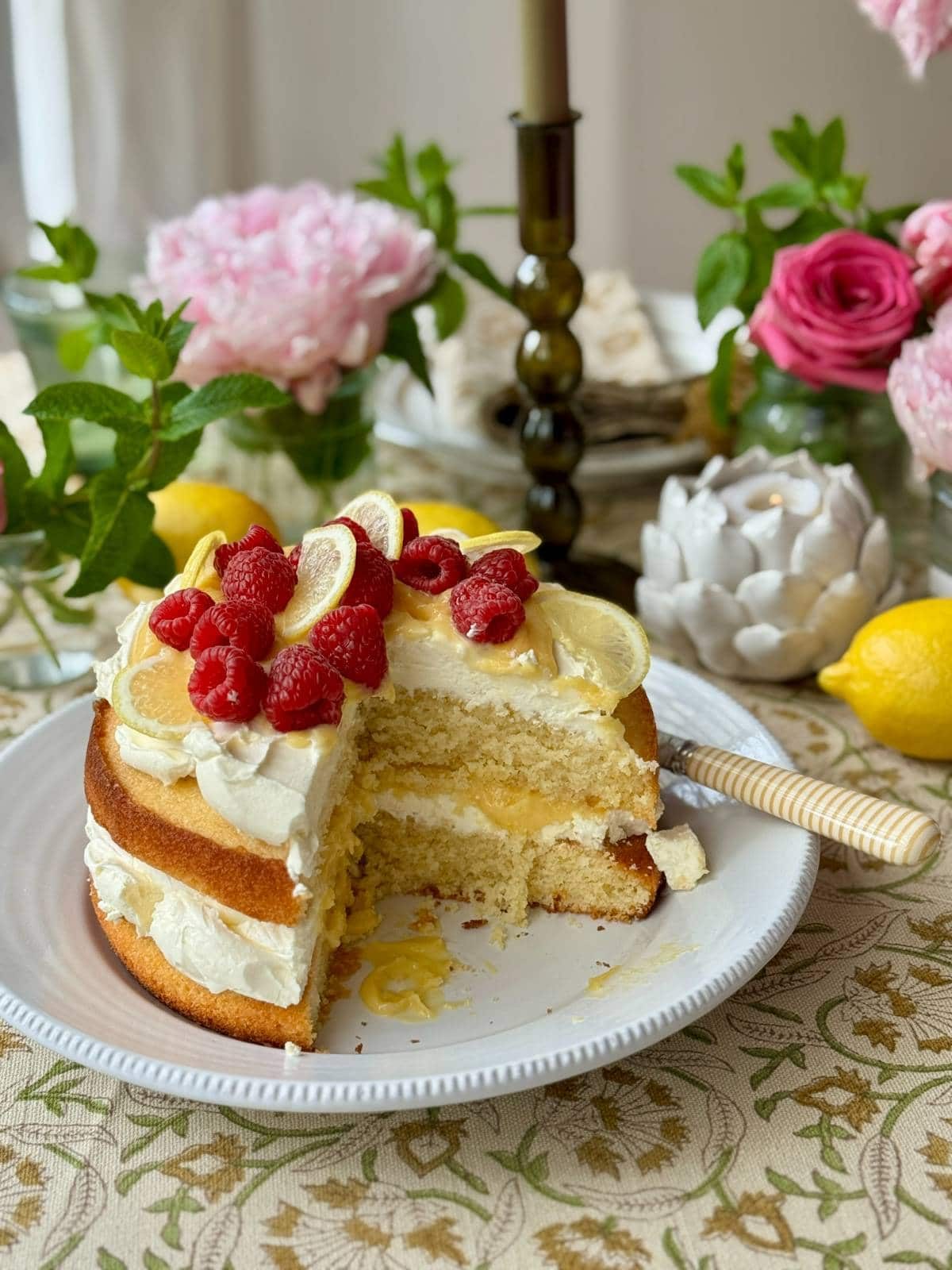 lemon curd cake on a plate with slice removed.
