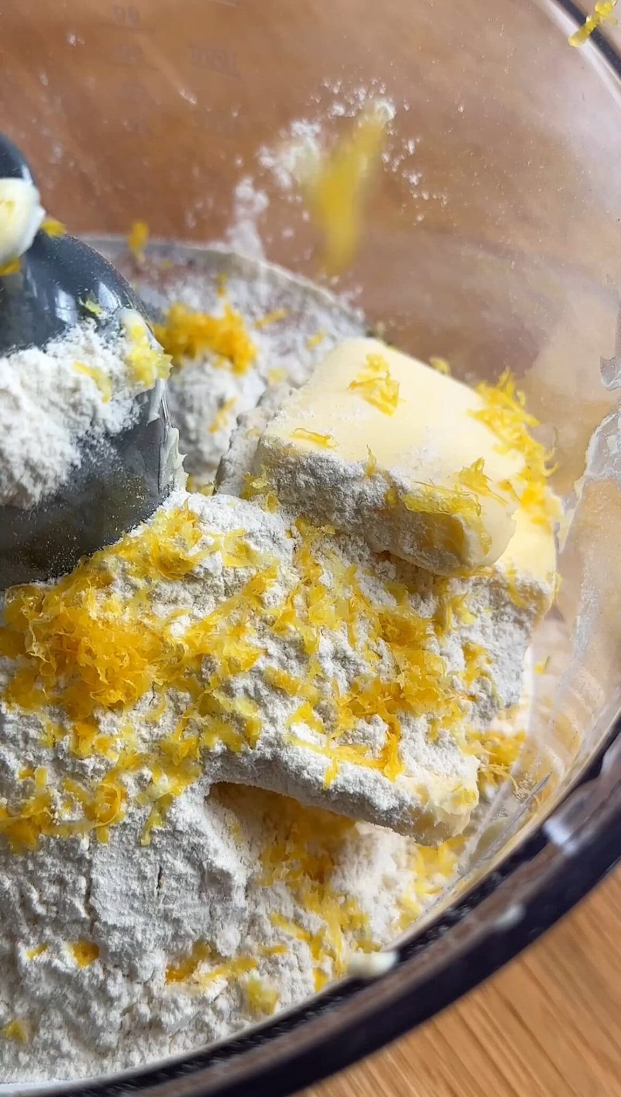 Zesting in lemon to the cake batter with sugar, butter, and flour.