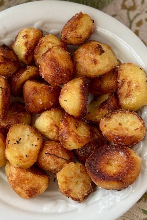 roasted white potatoes with rosemary in a white bowl.