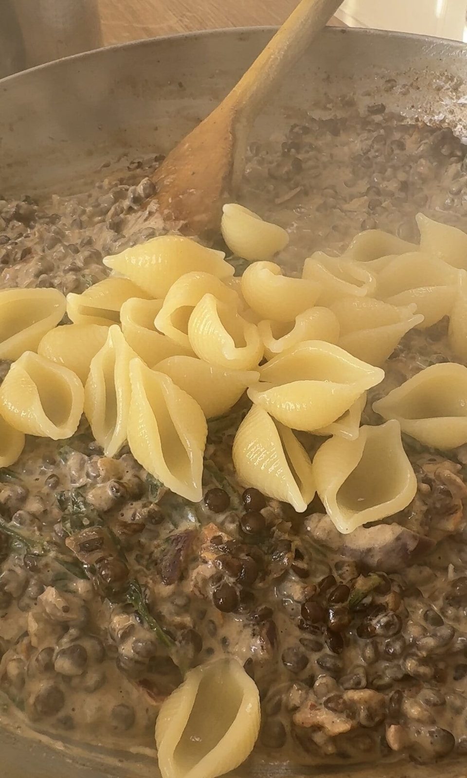 adding pasta to lentil ragu.