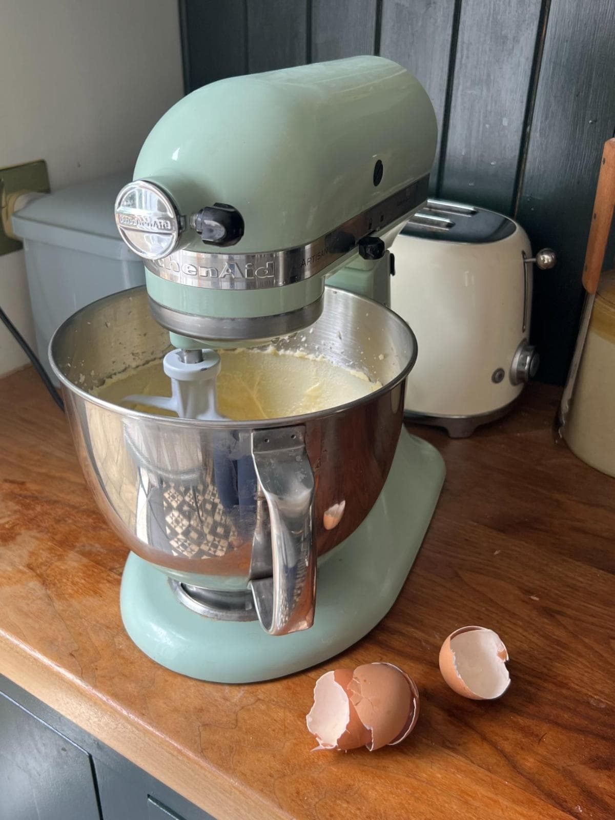 mixing butter and sugar in a stand mixer with eggs.