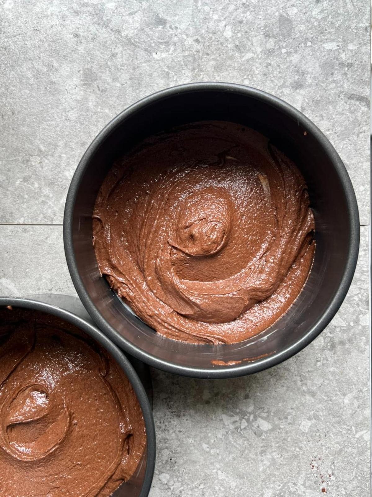 adding cake batter to the cake tins.