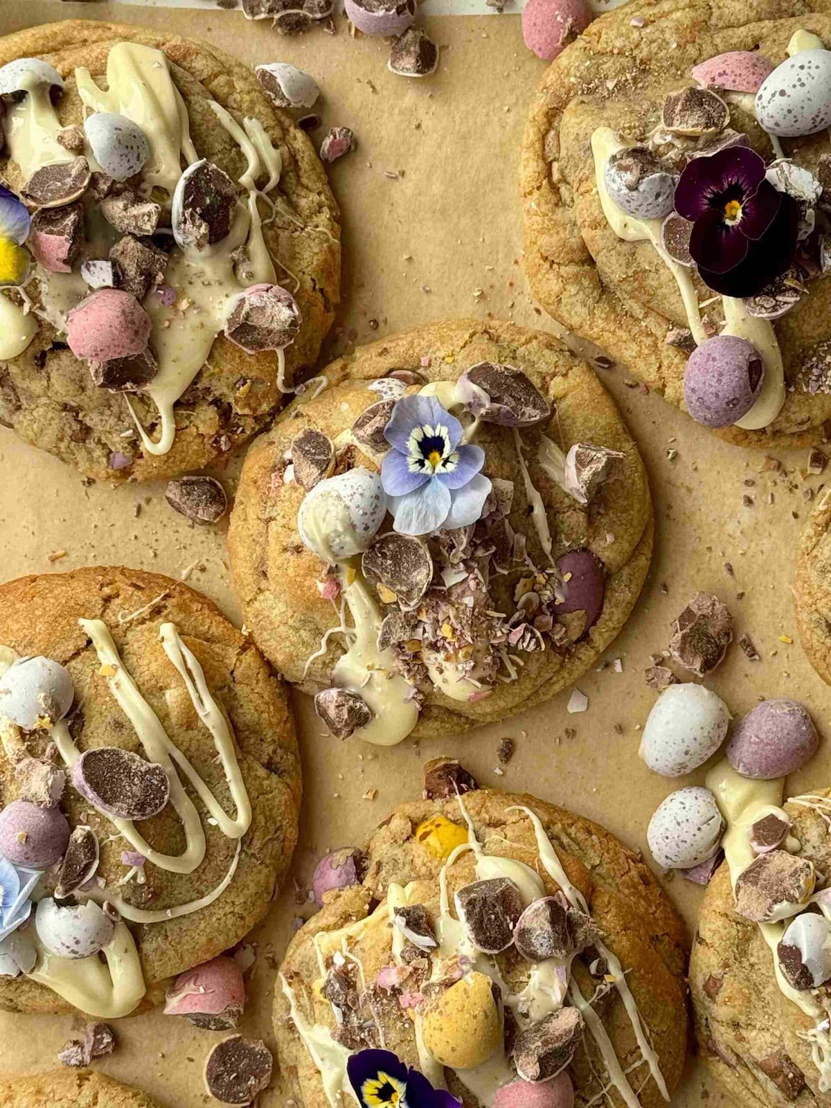 mini egg cookies drizzled with white chocolate with edible flowers.
