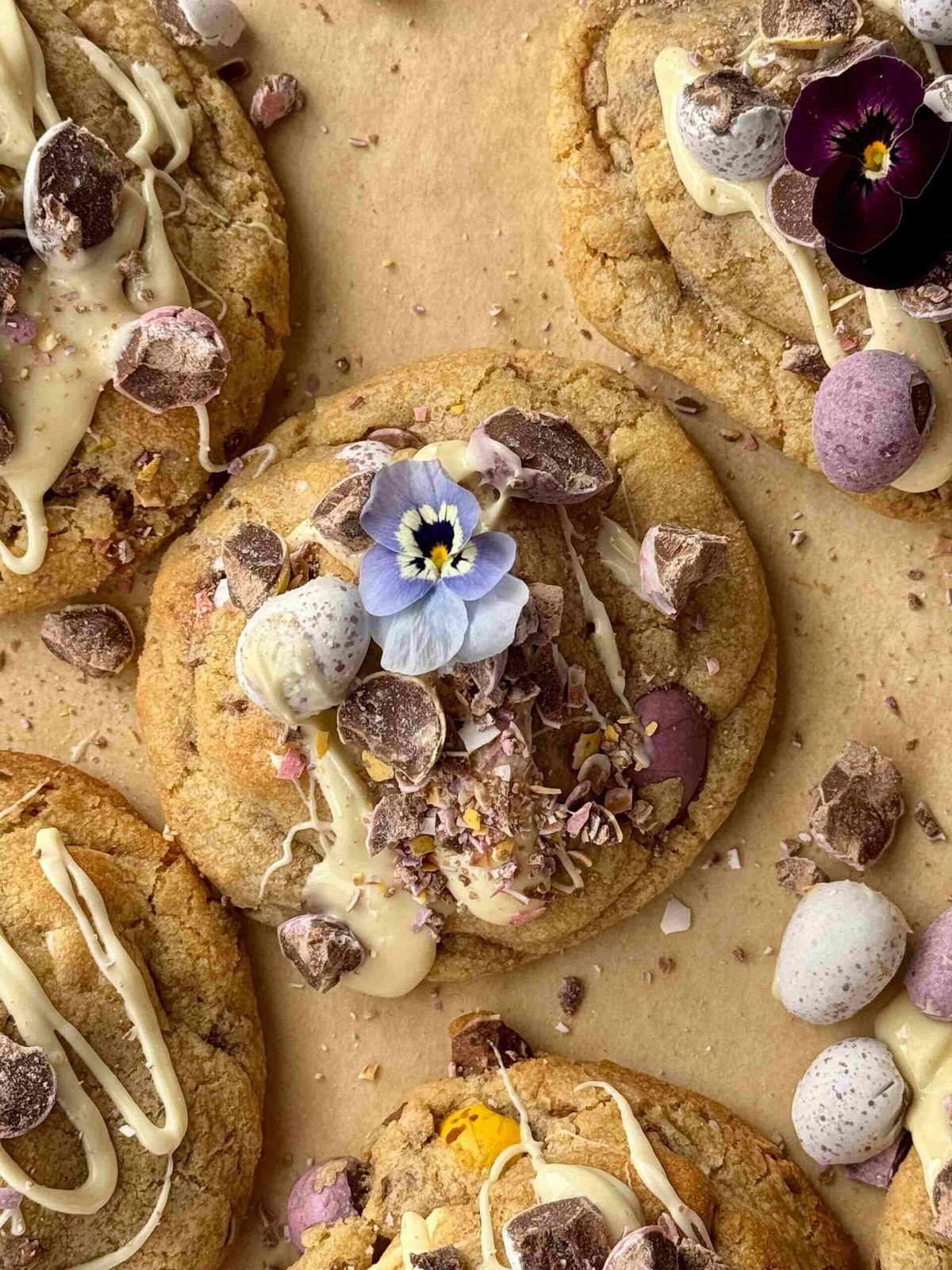 mini egg cookies drizzled with white chocolate with edible flowers.