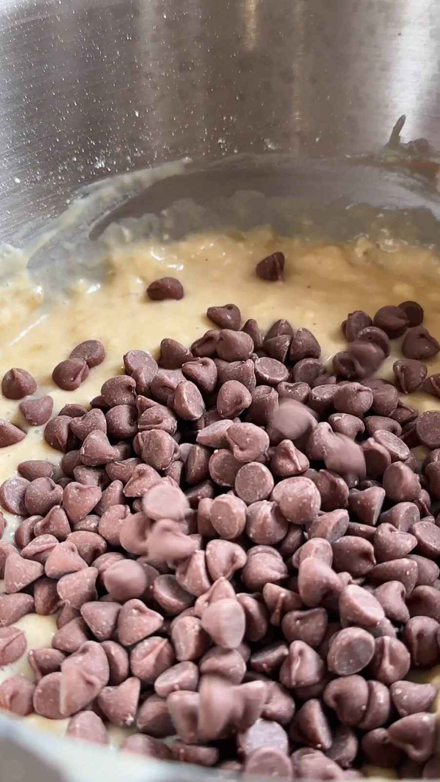 Folding in chocolate chips to banana bread batter.