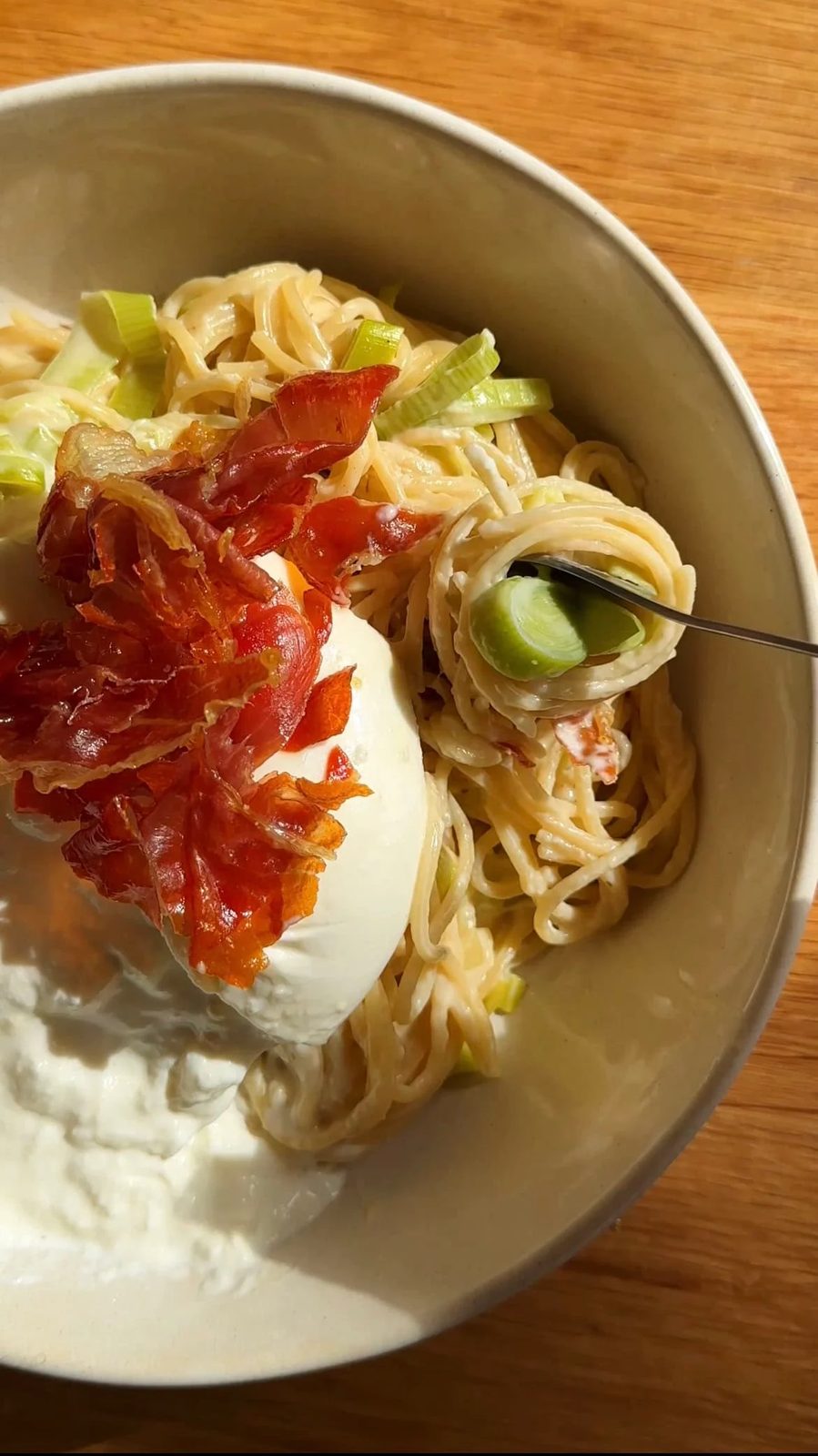 burrata and crispy parma ham on top of creamy leek pasta
