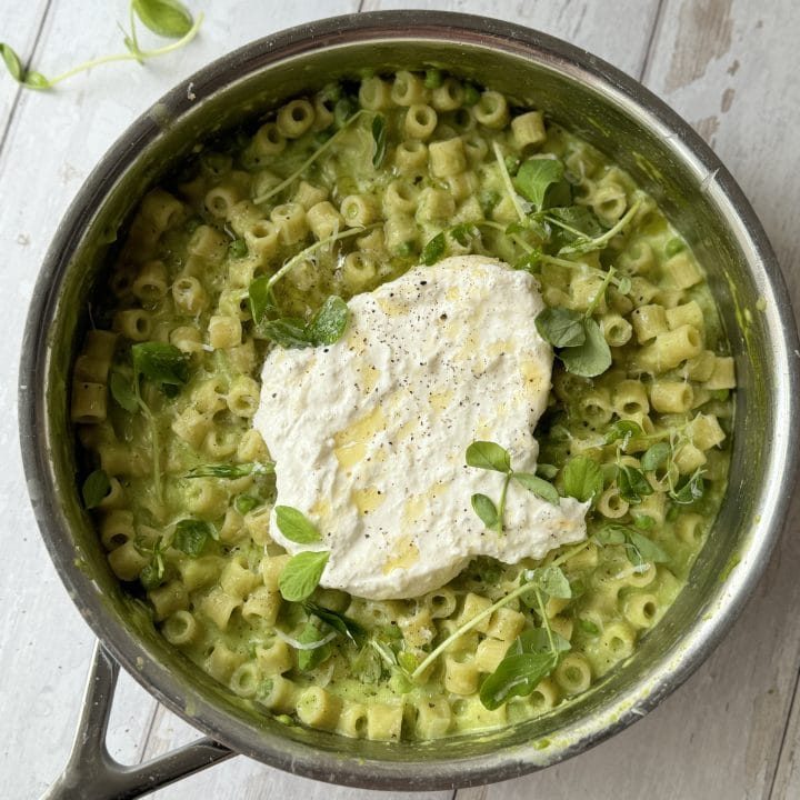 pasta and peas in a pan with burrata.