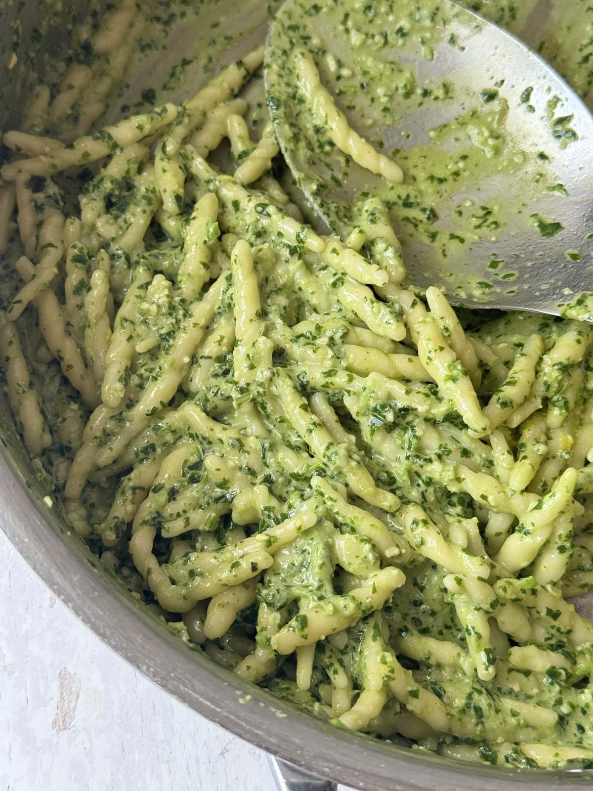 Pasta al pesto in steel pan.