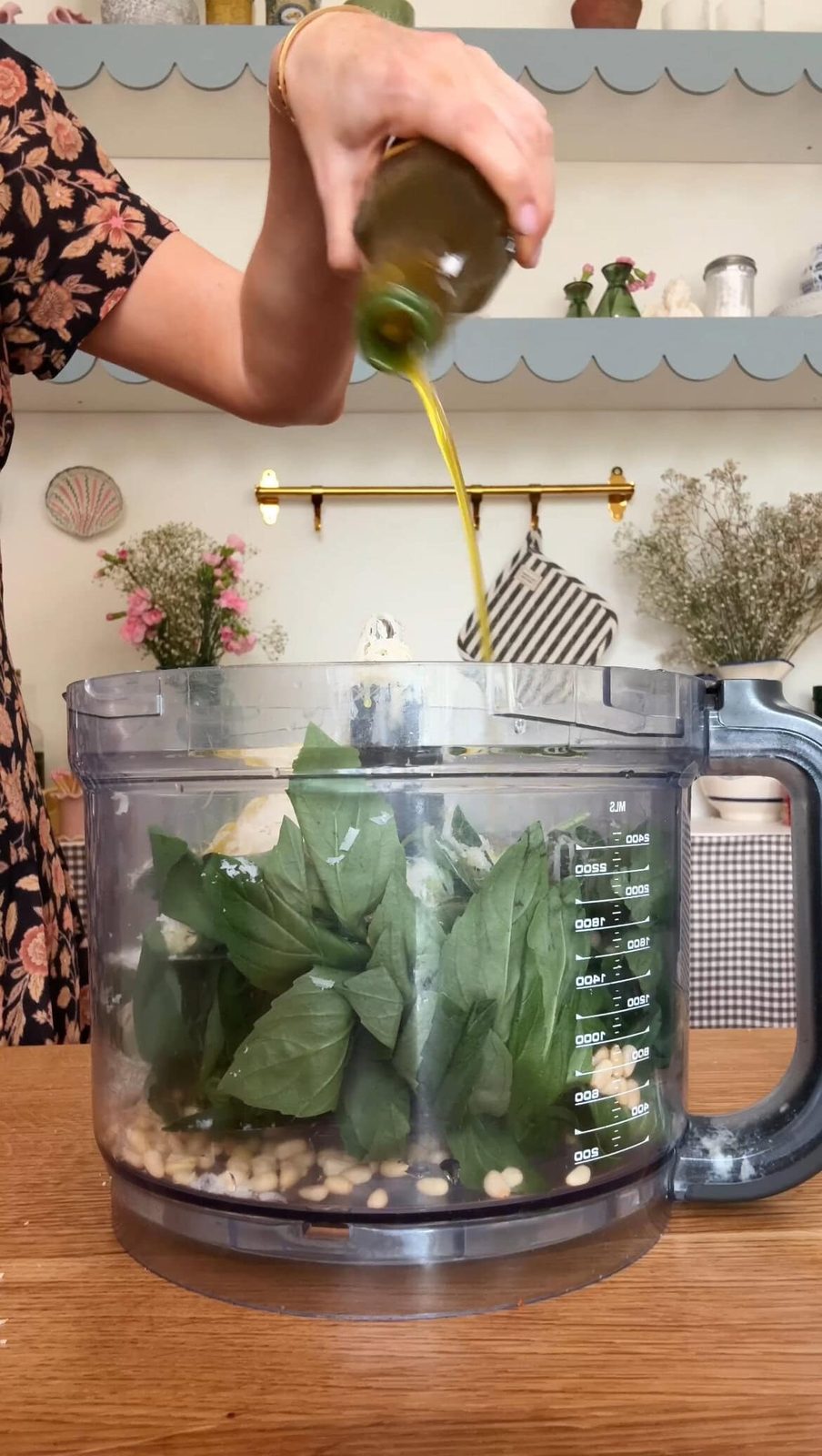 Pouring olive oil to the food processor for pesto.