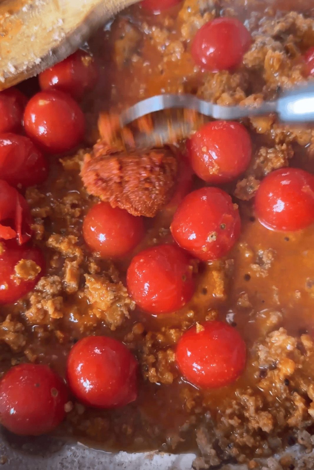 adding cherry tomatoes to the sauce.