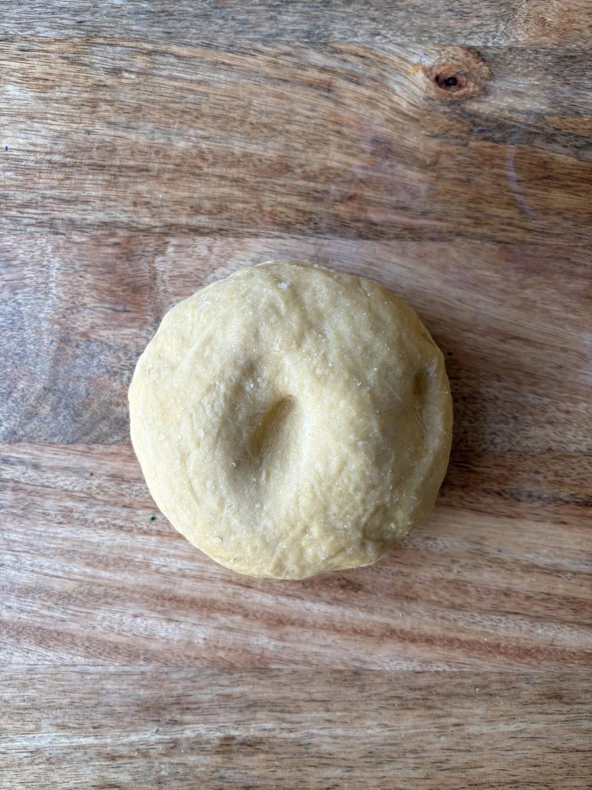 pushing a finger into pasta dough.