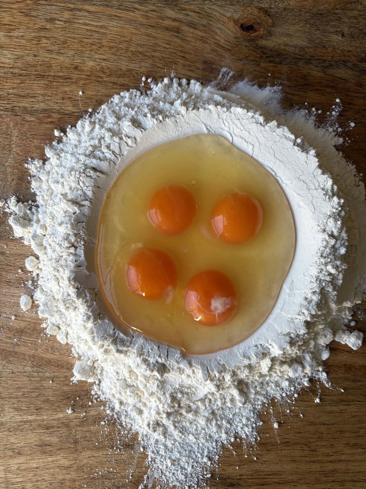 eggs cracked into a well of flour.