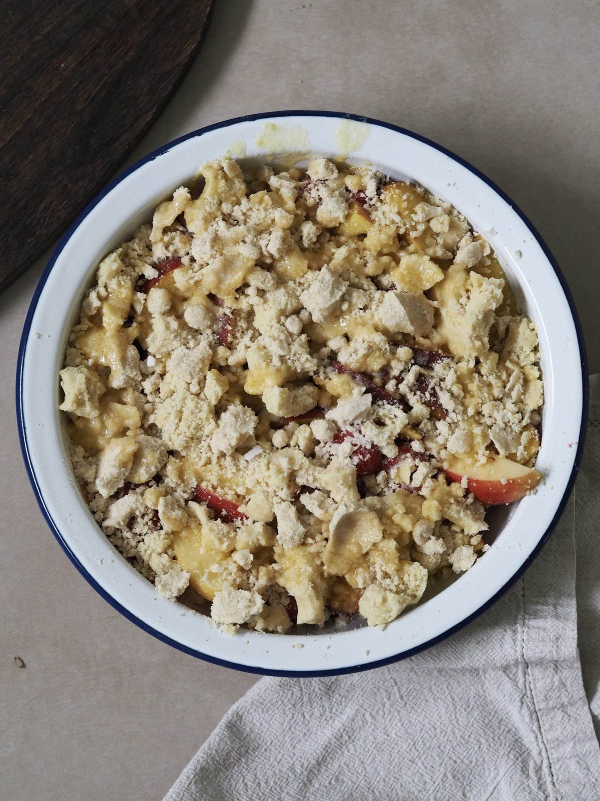 Unbaked peach, apple, and raspberry cobber in baking dish.