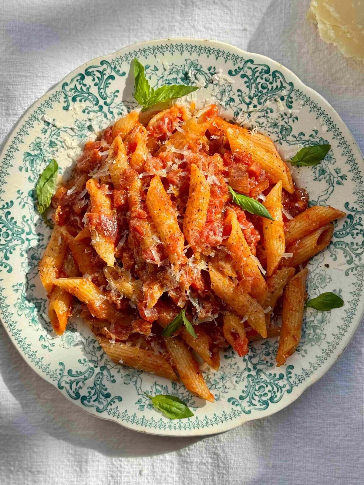 Penne amatriciana in a blue bowl.
